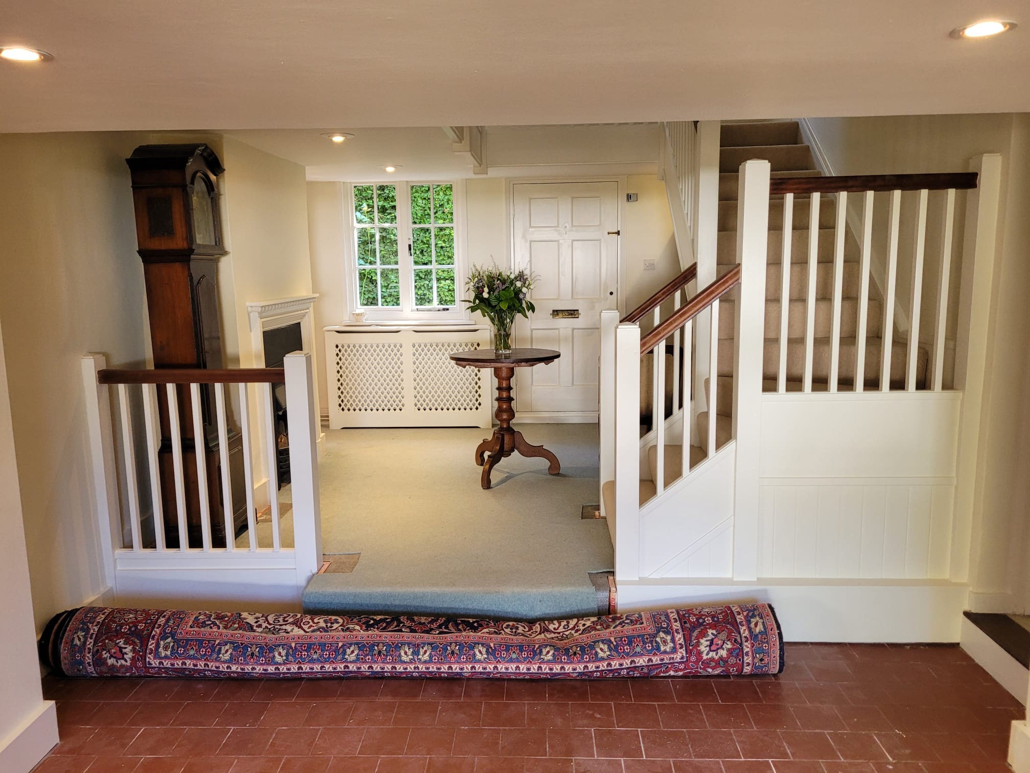 Period hallway with painted staircase and woodwork by DecorInnovations