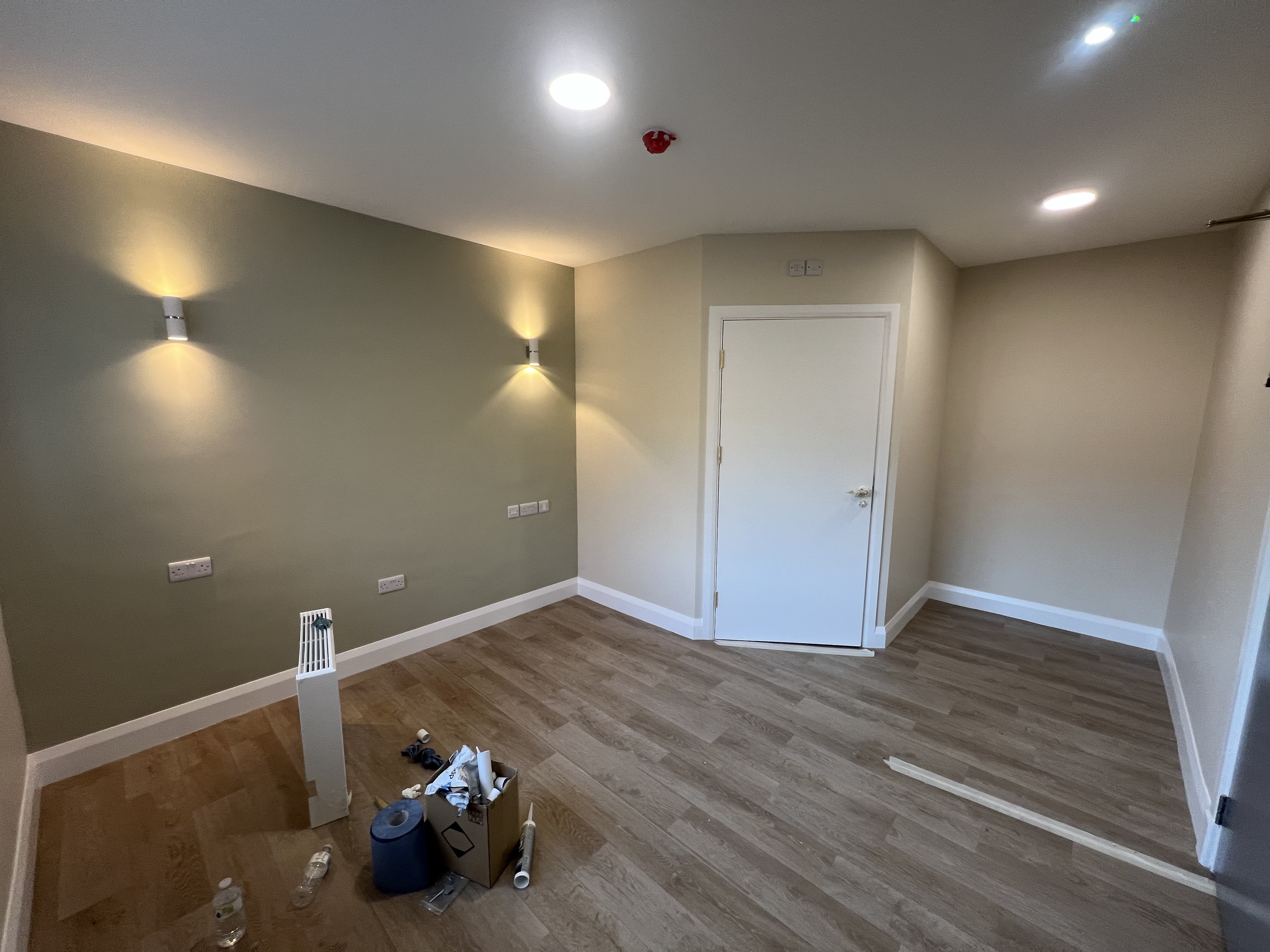 Modern room with sage green feature wall, cream walls, and white skirting